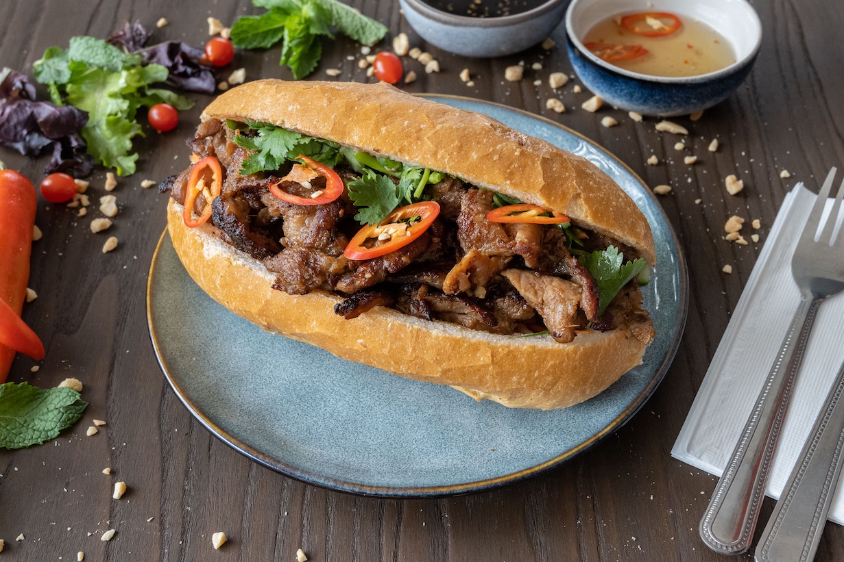 BBQ pork Bánh Mì on a blue plate
